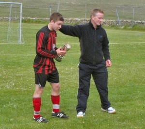 Captian Erik Thomson accepts the trophy